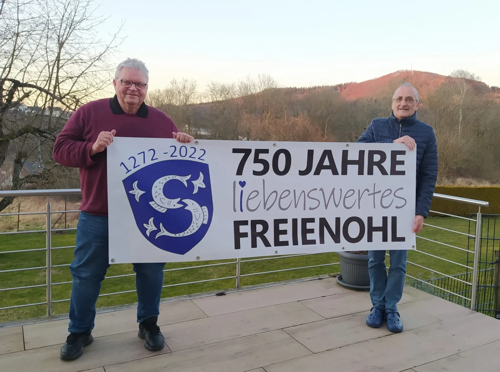 Das Banner für das Ortsjubiläum wird präsentiert