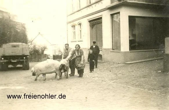 Herbert Schubert (Vater von Dieter und Monika Schubert) und Else, die damals auf dem Hof von Frohnen arbeitete. Beide treiben zwei Schweine von Frohnen zum Schlachten.