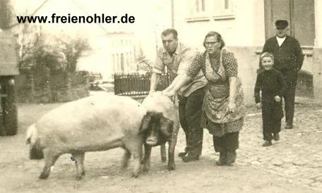 Herbert Schubert (Vater von Dieter und Monika Schubert) und Else, die damals auf dem Hof von Frohnen arbeitete. Beide treiben zwei Schweine von Frohnen zum Schlachten.