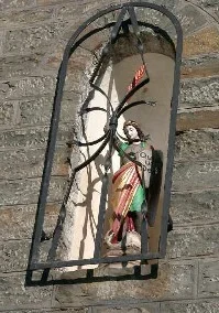 St. Michael erhebt sein Schwert in einer Mauernische über der Eingangstür